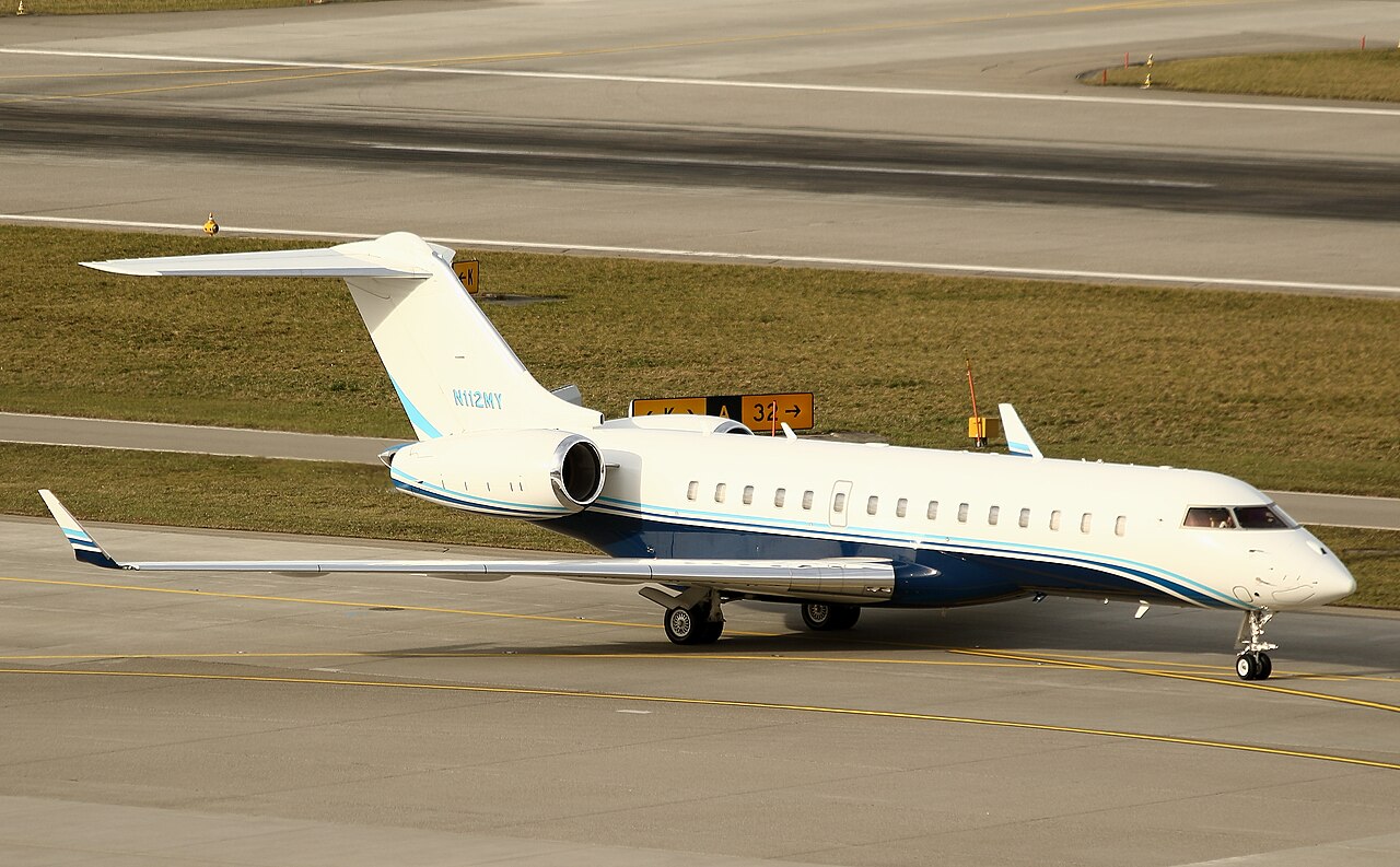 White and blue business jet on an airport taxiway